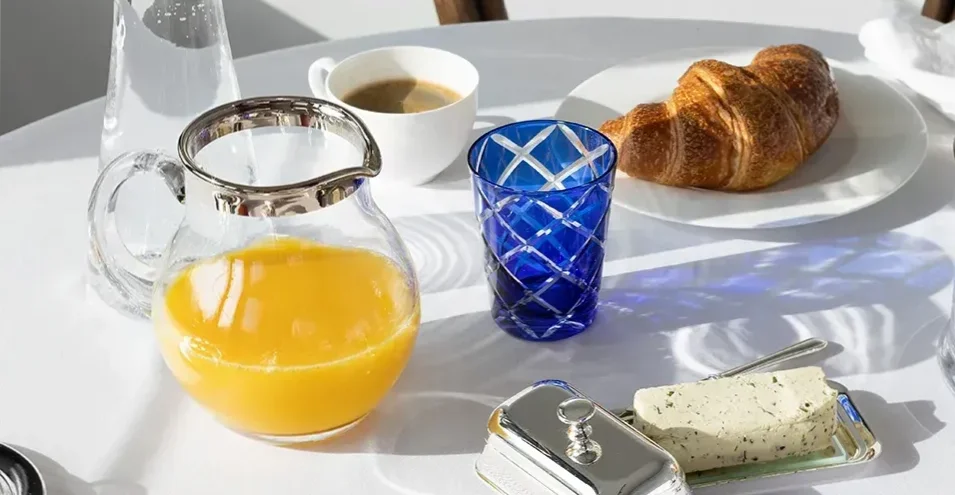 Glaskaraffe mit Saft auf gedecktem Frühstückstisch